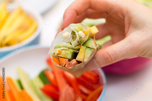Photo: Fresh spring roll with vegetable filling on vibrant background Fresh spring roll with vegetable filling on vibrant background