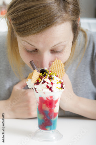 Photo: Young woman tasting cup of ice cream Young woman tasting cup of ice cream