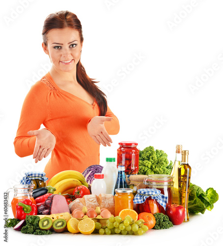 Photo: Young woman with assorted grocery products isolated on white Young woman with assorted grocery products isolated on white