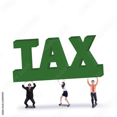 Photo: Business team lifts a tax sign Business team lifts a tax sign