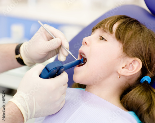 Photo: dentist using dental filling gun on kid dentist using dental filling gun on kid