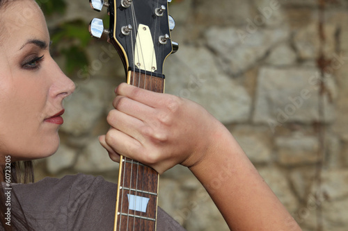 Photo: Profile of woman with guitar neck Profile of woman with guitar neck
