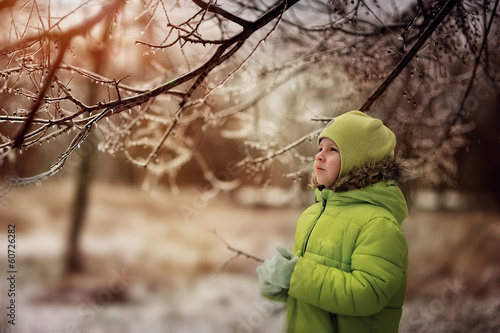 Photo: boy in a green suit walks in the park in winter with frozen tree boy in a green suit walks in the park in winter with frozen tree