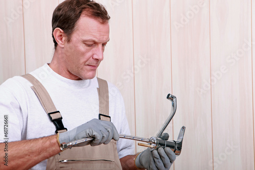 Photo: Handy man holding tap Handy man holding tap