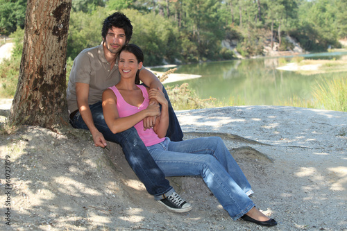 Photo: Young couple sitting by a lake Young couple sitting by a lake