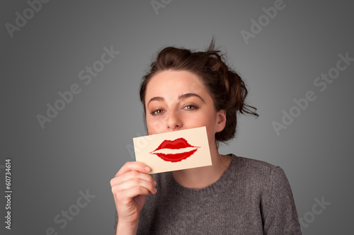 Photo: Happy pretty woman holding card with kiss lipstick mark Happy pretty woman holding card with kiss lipstick mark