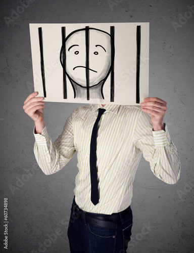 Photo: Businessman holding a paper with a prisoner behind the bars on i Businessman holding a paper with a prisoner behind the bars on i