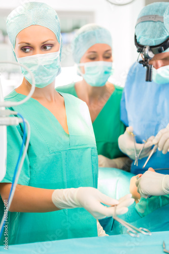 Photo: Chirurgen operieren in OP-Saal an Patienten Chirurgen operieren in OP-Saal an Patienten