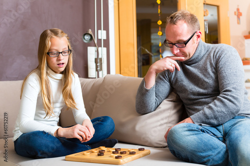 Photo: Vater und Tochter spielen das Spiel Dame Vater und Tochter spielen das Spiel Dame