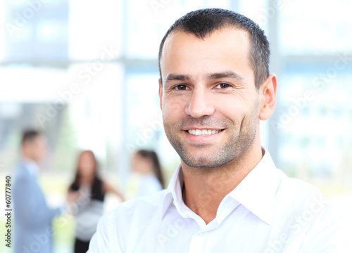 Photo: Businessman with colleagues in the background Businessman with colleagues in the background