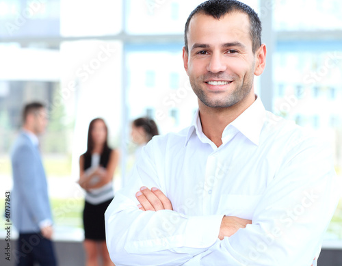 Photo: cross-armed leader looking at camera in working environment cross-armed leader looking at camera in working environment