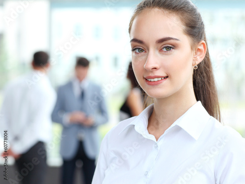 Photo: Face of beautiful woman on the background of business people Face of beautiful woman on the background of business people