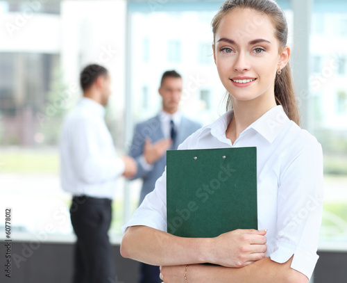 Photo: Face of beautiful woman on the background of business people Face of beautiful woman on the background of business people