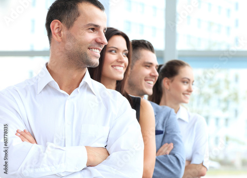 Photo: business team standing in a row at office and looking upwards business team standing in a row at office and looking upwards