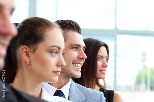 Photo: business team standing in a row at office and looking upwards business team standing in a row at office and looking upwards