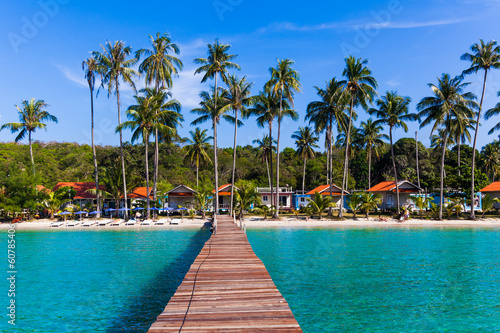 Photo: Wooden pathway. Tropical Resort. boardwalk on beach Wooden pathway. Tropical Resort. boardwalk on beach