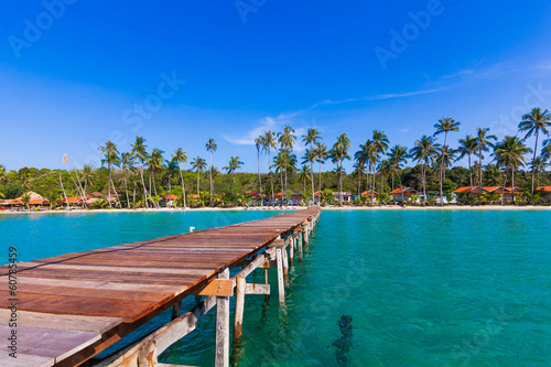 Photo: Wooden pathway. Tropical Resort. boardwalk on beach Wooden pathway. Tropical Resort. boardwalk on beach