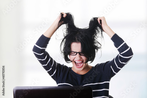 Photo: Frustrated woman working on laptop Frustrated woman working on laptop