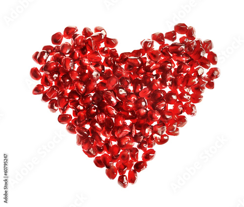 Photo: Red heart made of pomegranate seeds on white background Red heart made of pomegranate seeds on white background