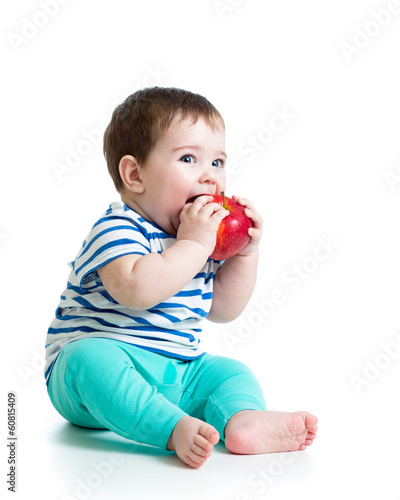 Photo: Baby boy eating red apple, isolated on white Baby boy eating red apple, isolated on white