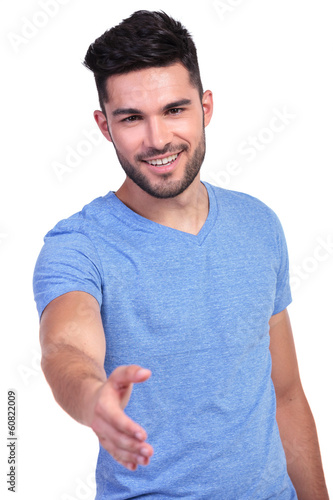 Photo: happy casual man welcomes you with a handshake happy casual man welcomes you with a handshake