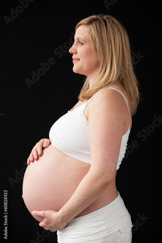 Photo: Portrait Of 9 months Pregnant Woman Wearing White On Black Backg Portrait Of 9 months Pregnant Woman Wearing White On Black Backg