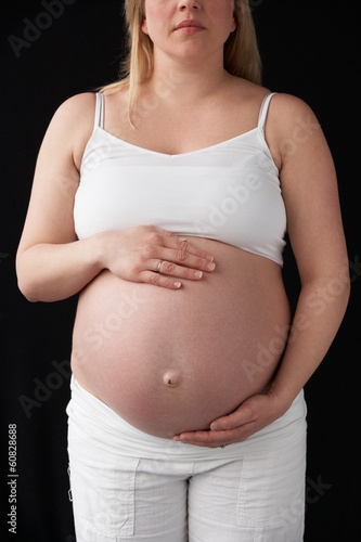 Photo: Close Up Portrait Of 9 months Pregnant Woman On Black Background Close Up Portrait Of 9 months Pregnant Woman On Black Background