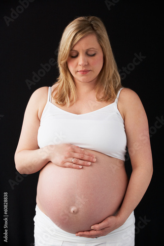 Photo: Portrait Of 9 months Pregnant Woman Wearing White On Black Backg Portrait Of 9 months Pregnant Woman Wearing White On Black Backg