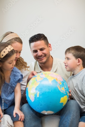 Photo: Family eploring globe Family eploring globe