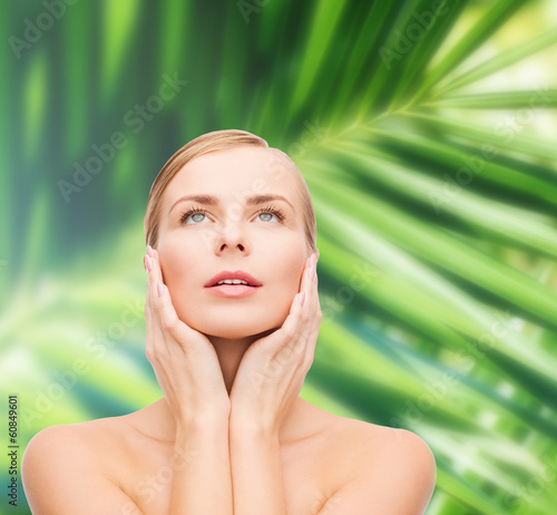 Photo: beautiful woman touching her face and looking up beautiful woman touching her face and looking up