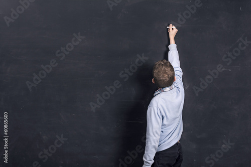 Photo: Boy standing in front of chalkboard writing Boy standing in front of chalkboard writing