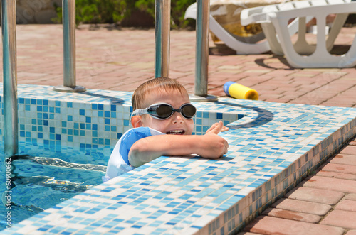 Photo: Cute little boy playing at the edge of a pool Cute little boy playing at the edge of a pool