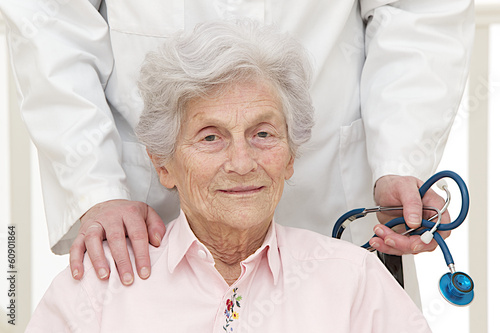 Photo: caring doctor with disabled senior patient in office caring doctor with disabled senior patient in office