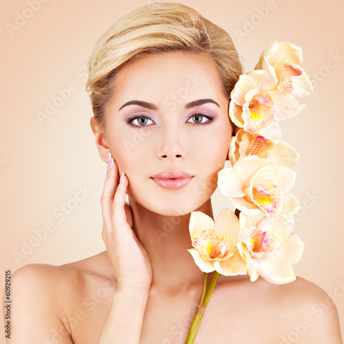 Photo: Woman with health skin and flowers at face. Woman with health skin and flowers at face.