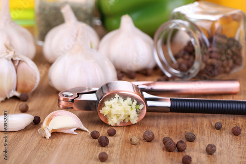 Photo: Composition with garlic press, fresh garlic and glass jars with Composition with garlic press, fresh garlic and glass jars with