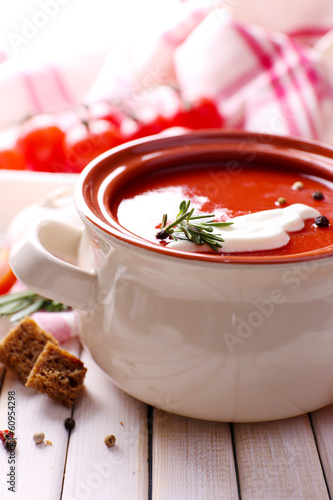 Photo: Tasty tomato soup on wooden table Tasty tomato soup on wooden table