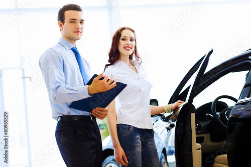 Photo: Young woman at car salon Young woman at car salon