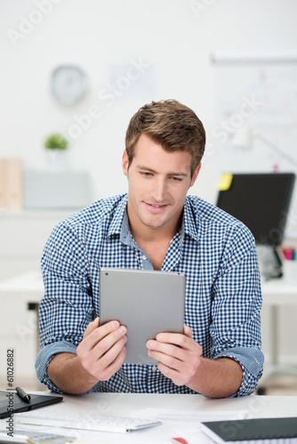 Photo: lächelnder mann im büro arbeitet mit tablet lächelnder mann im büro arbeitet mit tablet