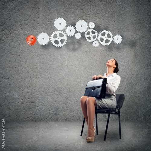 Photo: young business woman looking at the mechanism young business woman looking at the mechanism