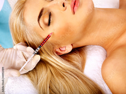 Photo: Woman giving botox injections. Woman giving botox injections.