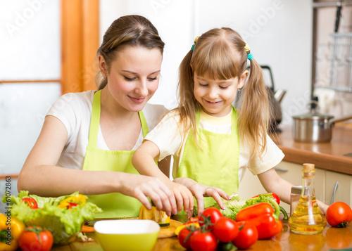 Photo: mom and kid girl preparing healthy food mom and kid girl preparing healthy food