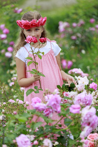 Photo: Rose garden - cute girl playing in the rose garden Rose garden - cute girl playing in the rose garden