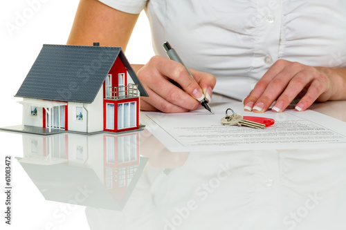 Photo: woman signs purchase agreement for house woman signs purchase agreement for house
