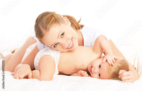 Photo: happy family mother and baby in bed happy family mother and baby in bed