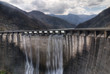 dam with overflow under cloudy sky dam with overflow under cloudy sky