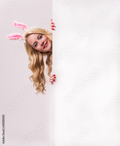 Photo: Bunny girl with blank banner on gray background. Bunny girl with blank banner on gray background.
