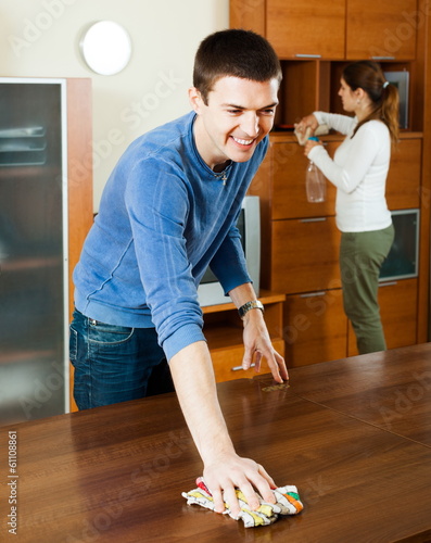 Photo: Man with wife dusting furniture Man with wife dusting furniture