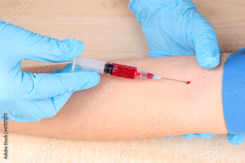 Photo: Nurse taking a blood sample, close up Nurse taking a blood sample, close up