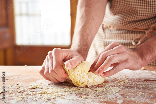 Photo: Hands baking dough on wooden table Hands baking dough on wooden table
