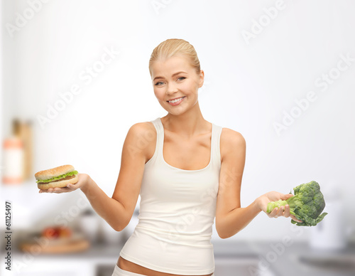 Photo: smiling woman with broccoli and hamburger smiling woman with broccoli and hamburger